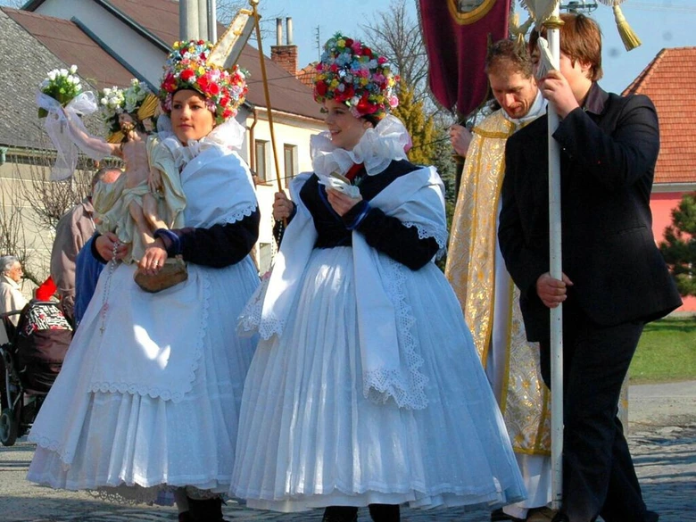 Ženy v tradičních kostýmech na Bílou sobotu s soškami.